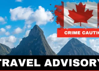 Urgent Travel Advisory for Saint Lucia: Image showing the iconic Pitons under a blue sky, with a Canadian flag marked 'Crime Caution' signifying a warning for Canadian travelers