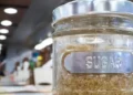 Brown sugar in a glass jar labeled 'sugar,' symbolizing the Caribbean Sugar Association's focus on regional sugar production.