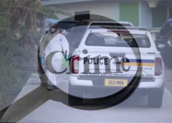 Law enforcement at the scene of a shooting in Grande Riviere, showing police officers and their vehicle as they investigate the crime scene.