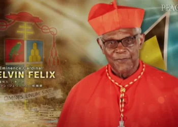 Cardinal Kelvin Felix in his church attire, standing with a serene expression, wearing his traditional red cassock and biretta, symbolizing his esteemed position in the Catholic Church.