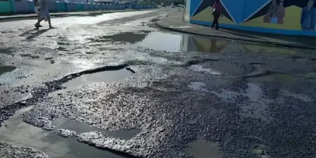 Pothole-ridden road in St. Lucia reflecting years of infrastructure neglect under Stephenson King's leadership.
