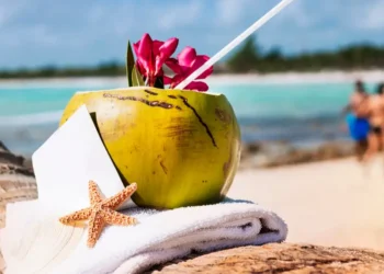 White sand beach with coconut and straw, starfish nearby, showcasing the serene setting and Caribbean tourism health tools initiative
