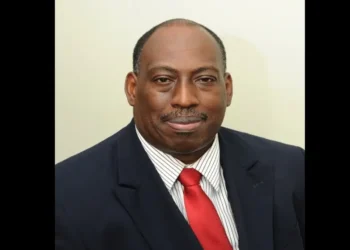 Dr. Dexter James in a red tie, pictured shortly before announcing "Millennium Heights CEO Resigns" amid healthcare challenges.