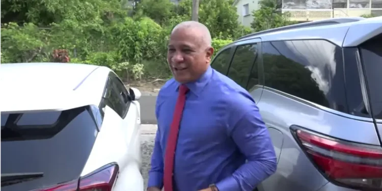 Ernest Hilaire, the man with many scandals, being interviewed by Lissa Joseph of DBS, wearing a blue shirt and red tie