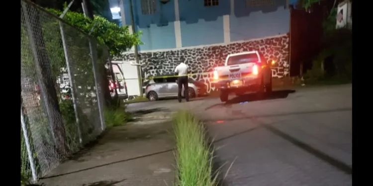 Saint Lucia ex-cop shooting crime scene with police vehicle, yellow tape, and officer standing guard amidst rising crime under Philip J. Pierre’s watch