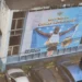 Shocking Saint Lucia billboard of Olympic gold medalist Julien Alfred on a dilapidated building, reflecting neglect and poor governance.