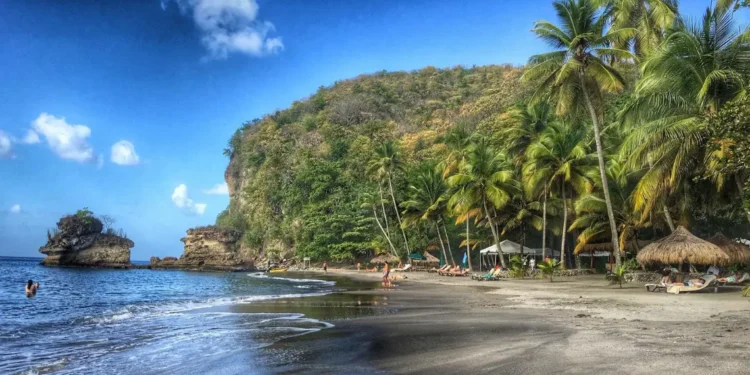 Stunning view of Anse Mamin Beach, one of the hidden gems in Saint Lucia, featuring pristine sands and crystal-clear waters surrounded by lush tropical vegetation.