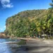 Stunning view of Anse Mamin Beach, one of the hidden gems in Saint Lucia, featuring pristine sands and crystal-clear waters surrounded by lush tropical vegetation.