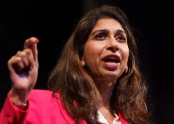 Suella Braverman leadership spotlight as she dons a pinkish outfit, embodying the pivotal decision not to pursue Tory leadership, influencing Conservative Party dynamics.