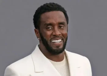 Diddy smiling in a tan suit before his Diddy Manhattan hotel arrest amid a high-profile federal investigation.