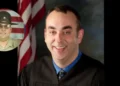 Judge Kevin Mullins in a black robe and Sheriff Shawn M. Stines in uniform, related to the Kentucky Sheriff Charged with Murder of Judge Kevin Mullins case.