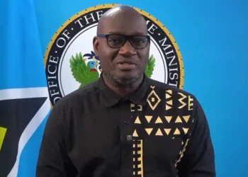 Moses Jn Baptiste under fire as he stands in front of the Office of the Prime Minister seal amid Saint Lucia’s healthcare crisis.