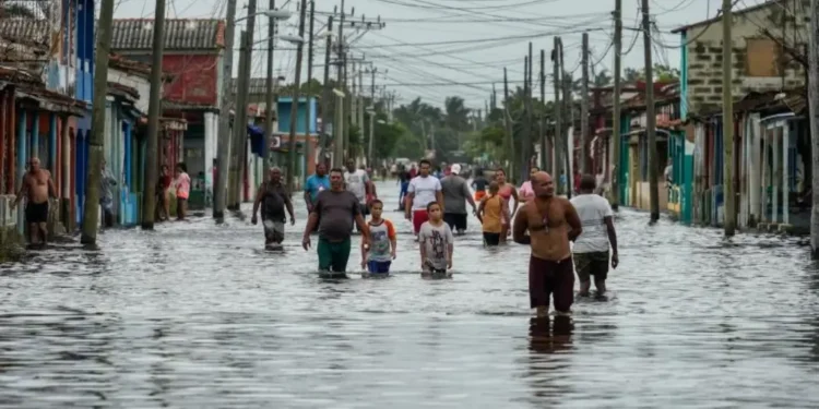 Residents wade through flooded streets as Tropical Storm Helene weakens after passing, causing severe flooding in Batabano, Cuba. (AP Photo/Ramon Espinosa)