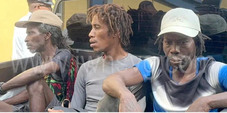 Three Saint Lucians denied bail in cocaine bust sitting in the back of a police pickup in Saint Vincent after being charged with trafficking 22 kilograms of cocaine.