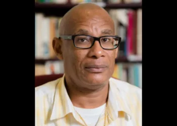 Portrait of Damian Greaves in a yellow shirt, symbolizing Damian Greaves return to OKEU Hospital amid renewed fears of healthcare failures.