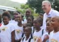 Allen Chastanet birthday message celebrated as he poses with smiling schoolchildren in Soufriere, reflecting his dedication to Saint Lucia.