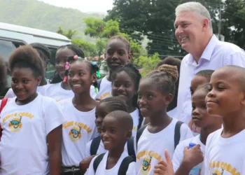 Allen Chastanet birthday message celebrated as he poses with smiling schoolchildren in Soufriere, reflecting his dedication to Saint Lucia.