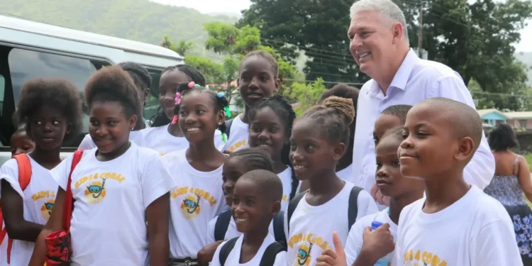 Allen Chastanet birthday message celebrated as he poses with smiling schoolchildren in Soufriere, reflecting his dedication to Saint Lucia.