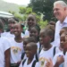 Allen Chastanet birthday message celebrated as he poses with smiling schoolchildren in Soufriere, reflecting his dedication to Saint Lucia.