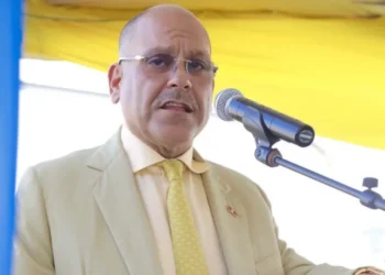 Asot Michael speaking at a podium during a public event, representing Antigua in mourning following his tragic passing