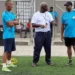 Emmanuel Bellas, legendary Vieux Fort football coach, in a white shirt during a coaching session, sharing his expertise and leadership.