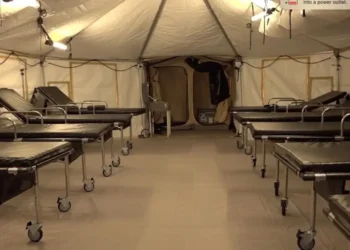 Interior view of Saint Lucia field hospital abandoned by SLP government, showing rows of empty hospital beds in unused medical facility.