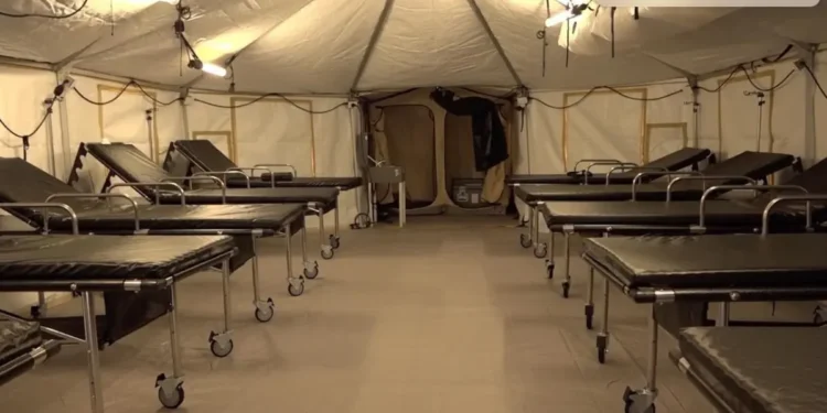 Interior view of Saint Lucia field hospital abandoned by SLP government, showing rows of empty hospital beds in unused medical facility.