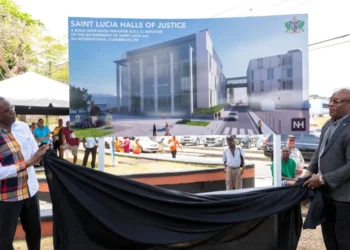 Prime Minister Philip J. Pierre and Minister Richard Frederick unveiling the Halls of Justice project billboard, showcasing plans amid the Halls of Justice seawater crisis in Saint Lucia.