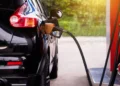 Black vehicle refueling, highlighting the benefits of lower fuel prices in Barbados for consumers.