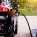 Black vehicle refueling, highlighting the benefits of lower fuel prices in Barbados for consumers.