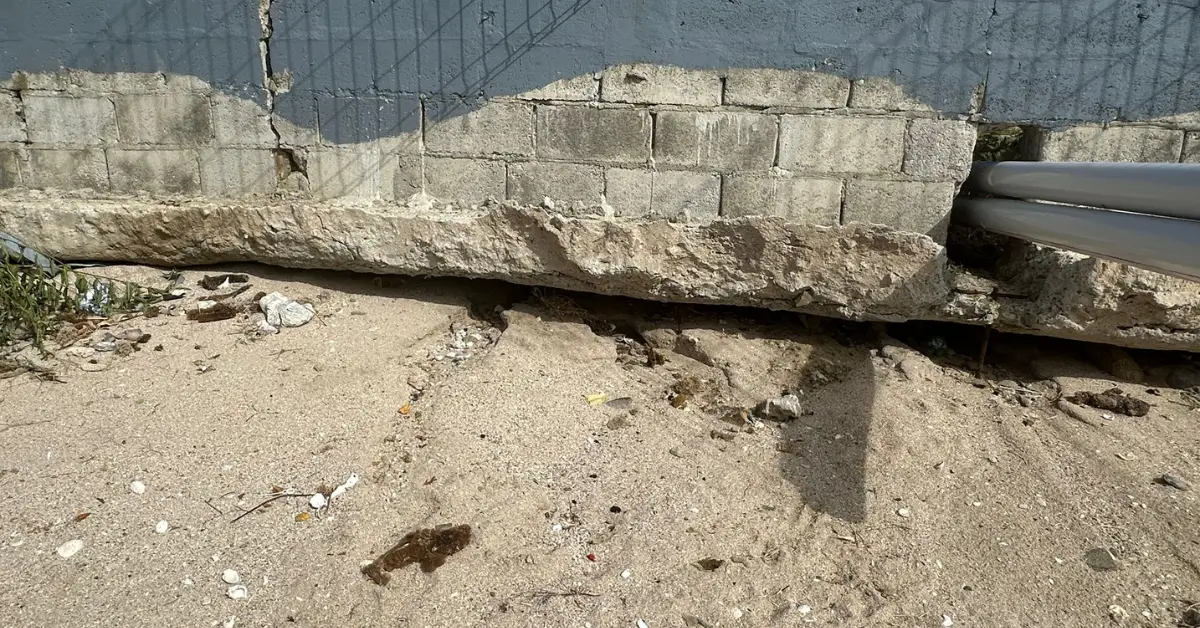 Exposed foundation and eroded support under Gros Islet park wall, underscoring weak construction integrity. Exposed foundation and eroded support under Gros Islet park wall, underscoring weak construction integrity.