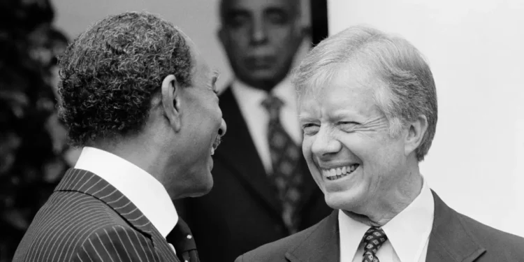 Jimmy Carter inspiring legacy shown as he smiles with Anwar Sadat during diplomatic talks.