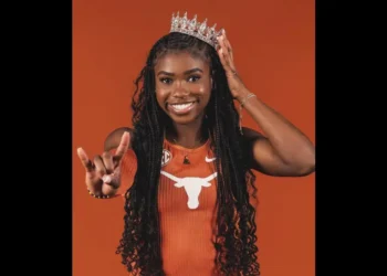 Naomi London in Texas Longhorns uniform, smiling with a crown and hand gesture.