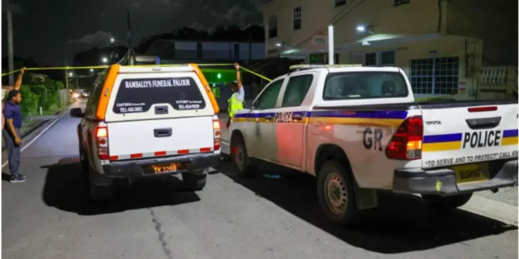 Police vehicles and a funeral hearse at the scene of the Corinth Armed Robber Shot incident in Saint Lucia during a late-night investigation.