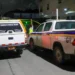 Police vehicles and a funeral hearse at the scene of the Corinth Armed Robber Shot incident in Saint Lucia during a late-night investigation.