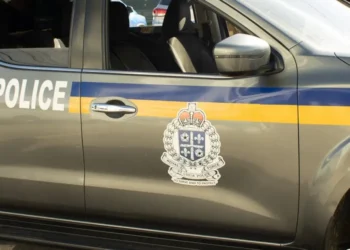 Side view of a Royal Saint Lucia Police Force vehicle, featuring official insignia and markings, actively used in the Vincentian National Shooting investigation on Water Works Road.
