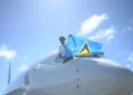 St Lucian pilot Tevin Belasco proudly waves the national flag upon landing, symbolizing achievement amidst St Lucia Left Behind.