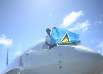 St Lucian pilot Tevin Belasco proudly waves the national flag upon landing, symbolizing achievement amidst St Lucia Left Behind.
