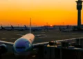 Airplane parked at an international airport during sunrise, reflecting global travel opportunities highlighted in 2025 airfare trends.