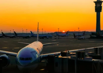 Airplane parked at an international airport during sunrise, reflecting global travel opportunities highlighted in 2025 airfare trends.