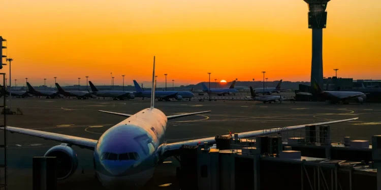 Airplane parked at an international airport during sunrise, reflecting global travel opportunities highlighted in 2025 airfare trends.