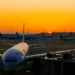 Airplane parked at an international airport during sunrise, reflecting global travel opportunities highlighted in 2025 airfare trends.
