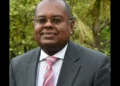 Dr. James Fletcher, a distinguished St. Lucian climate advocate and CARICOM Climate Envoy, pictured in a formal suit outdoors.