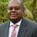 Dr. James Fletcher, a distinguished St. Lucian climate advocate and CARICOM Climate Envoy, pictured in a formal suit outdoors.