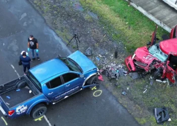 Fatal Gros Islet Highway collision showing a damaged red Suzuki Swift and blue Mitsubishi Sportero as investigators examine the scene.
