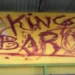 Graffiti reading King Baros defacing a bus shelter in Belle Vue, highlighting the Belle Vue vandalism incident addressed by the RSLPF crackdown.