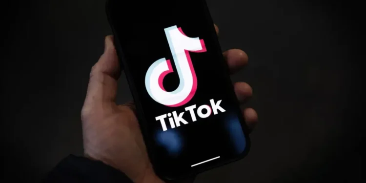 Hand holding a smartphone displaying the TikTok logo, as TikTok shutdown looms over security concerns and legal debates.