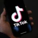 Hand holding a smartphone displaying the TikTok logo, as TikTok shutdown looms over security concerns and legal debates.