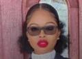 Shantrese Dorsett, St Kitts Nevis Crown Counsel charged in a high-profile murder case, poses in professional attire in front of a wooden door.