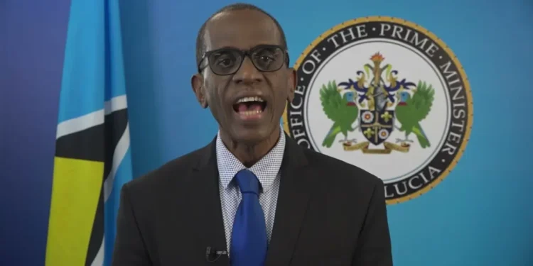 St Lucia PM Philip Pierre speaking in front of the Office of the Prime Minister emblem and Saint Lucia flag